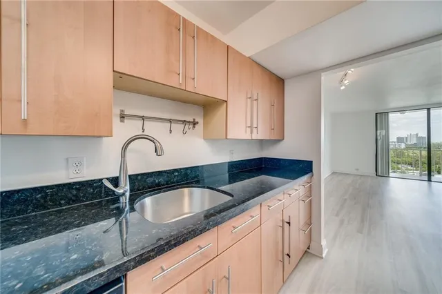 a kitchen with granite countertop a sink a stove and cabinets