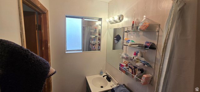 47 Larson Road Vernon, UT 84080 - Photo 15 of 34 Bathroom featuring a vanity with an integrated sink, a wall-mounted light fixture, and a window