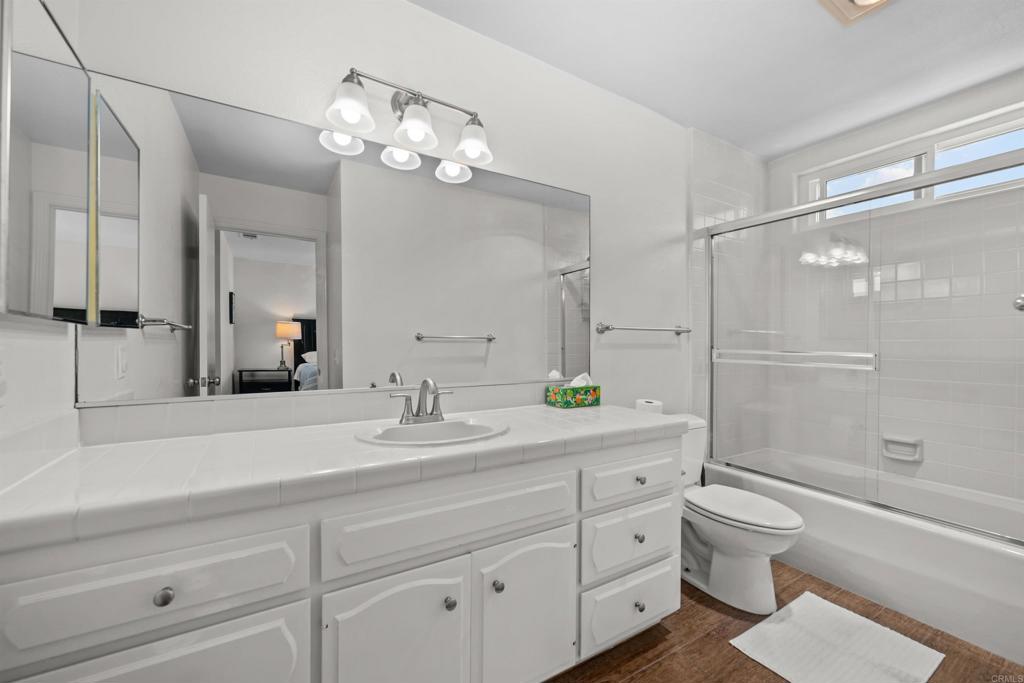 368 Hemlock Avenue Carlsbad, CA 92008 - Photo 20 of 32 a spacious bathroom with a granite countertop toilet a sink a mirror a shower a window and vanity
