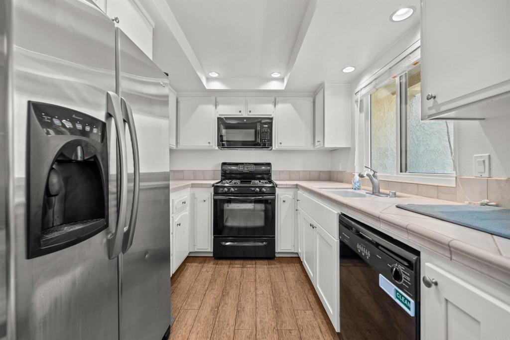 368 Hemlock Avenue Carlsbad, CA 92008 - Photo 9 of 32 a kitchen with stainless steel appliances granite countertop a sink a stove and a refrigerator