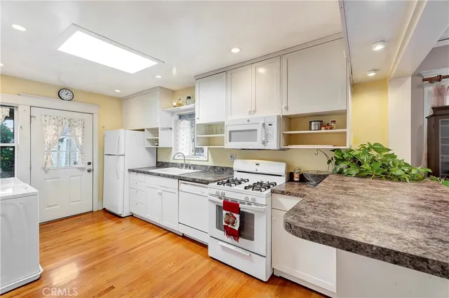 a kitchen with stainless steel appliances kitchen island granite countertop a stove a sink and a refrigerator