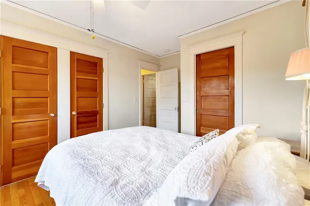 a large white bed in a bedroom next to a cabinet