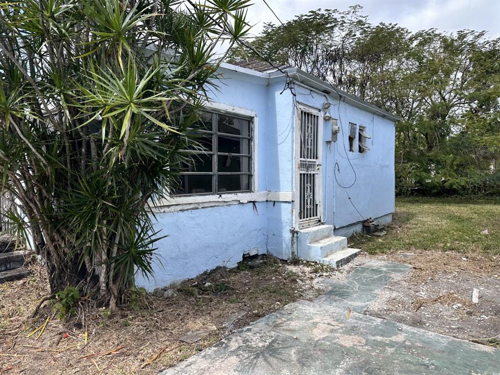 2161 Northwest 50th Street Miami, FL 33142 - Photo 2 of 4 a house with a tree in front of it