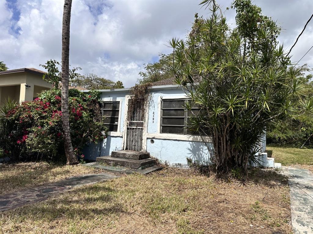 2161 Northwest 50th Street Miami, FL 33142 - Photo 3 of 4 a front view of a house with a yard and garage