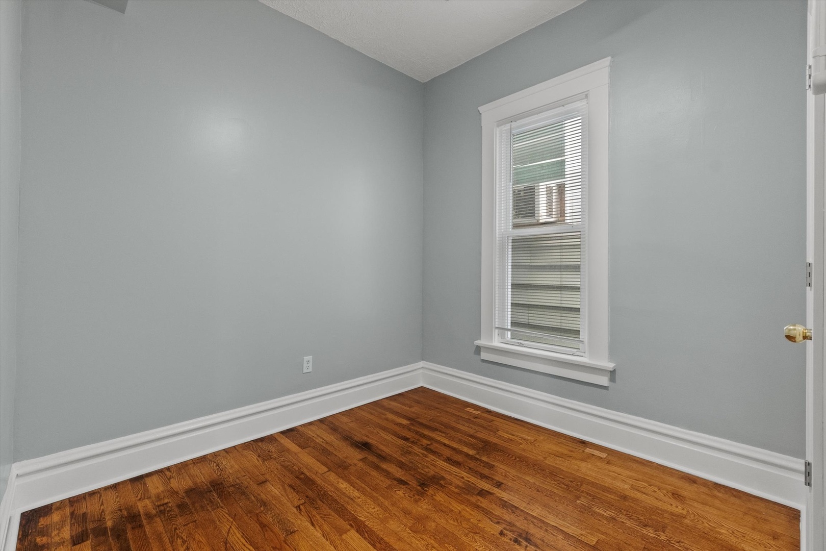 820 East 89th Place, Unit 2 Chicago, IL 60619 - Photo 10 of 15 an empty room with wooden floor and windows