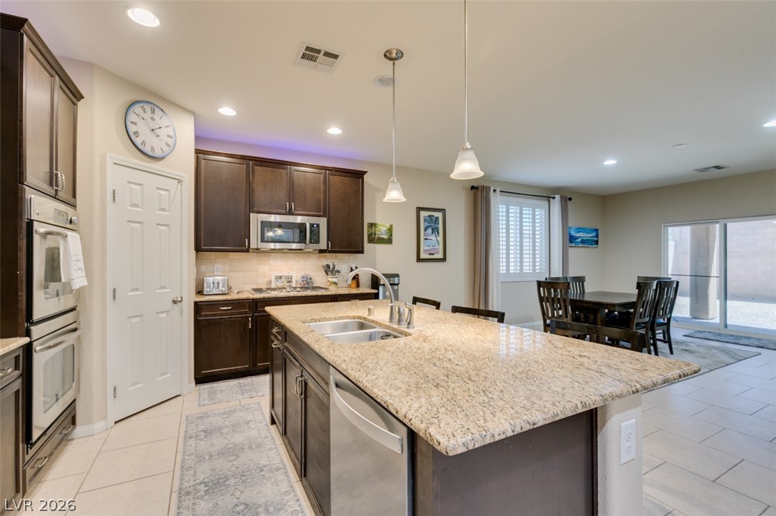 7375 Campbell Ranch Avenue Las Vegas, NV 89179 - Photo 9 of 45 An inviting kitchen with rich cabinetry and an expansive island anchors this open-concept living space.