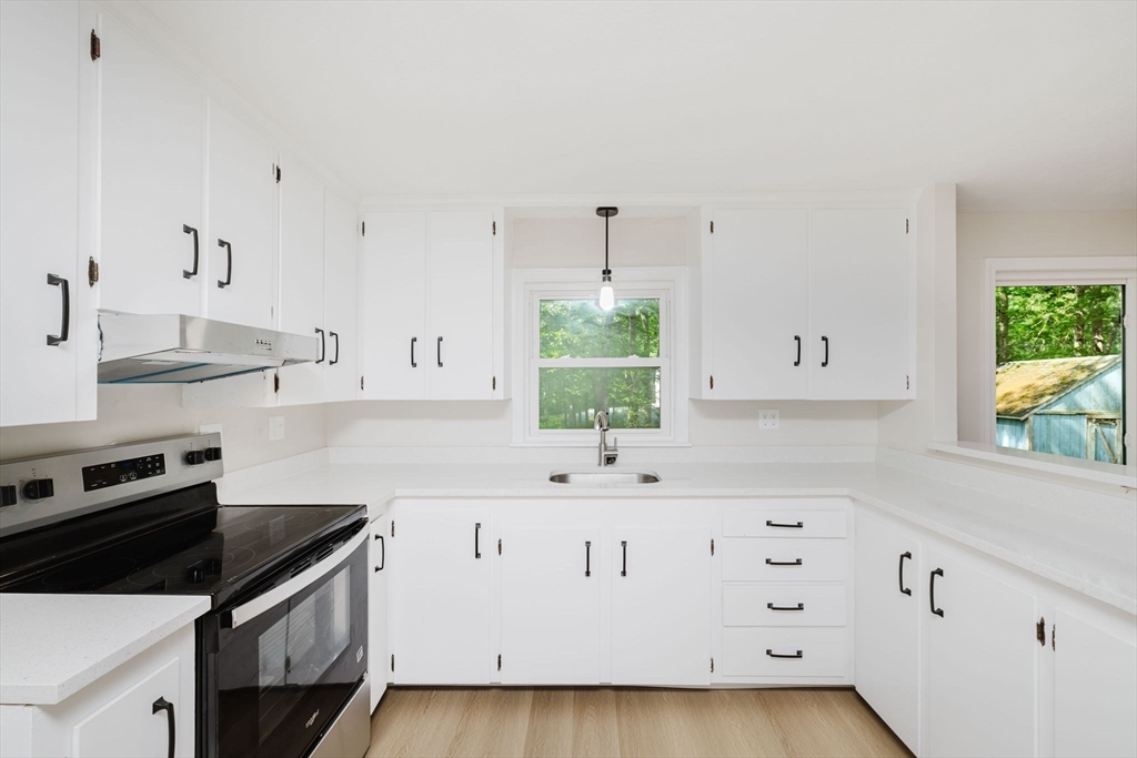 24 Sagamore Road Attleboro, MA 02703 - Photo 14 of 39 a kitchen with granite countertop a stove a sink and a white cabinets