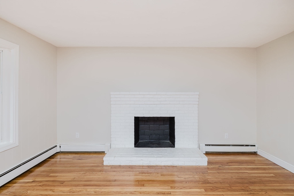 24 Sagamore Road Attleboro, MA 02703 - Photo 21 of 39 a living room with a fireplace and wooden floor