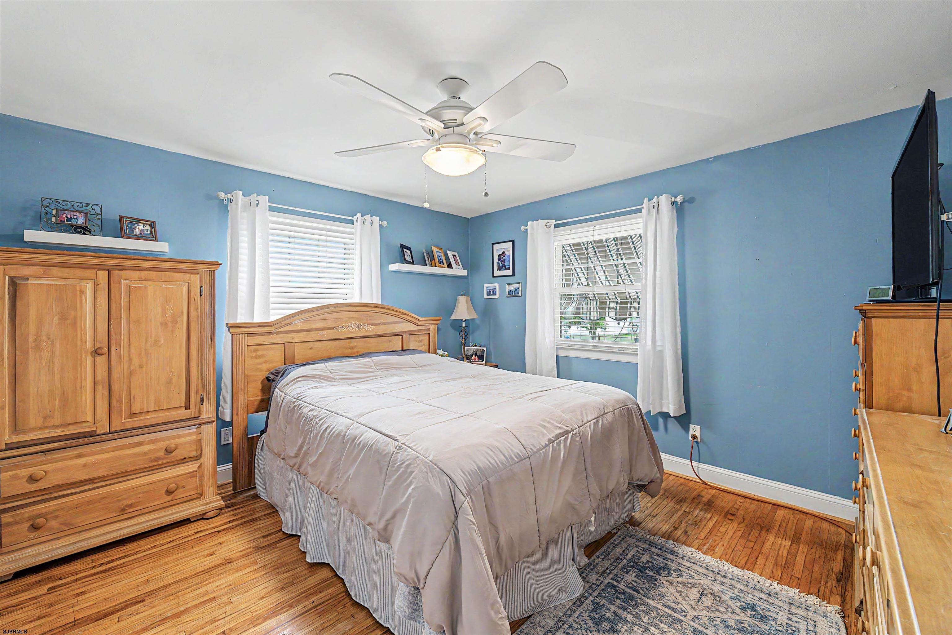 125 Exton Road Somers Point, NJ 08244 - Photo 23 of 35 a bedroom with a large bed a chandelier and windows