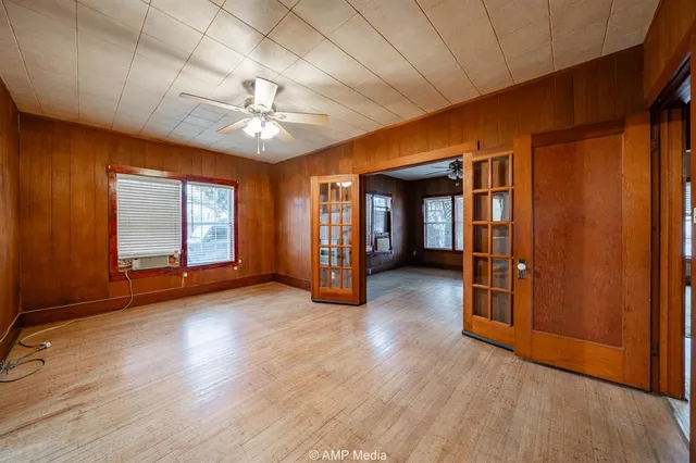 a view of an empty room with window and wooden floor