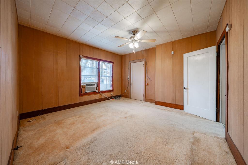 1104 North Avenue Avenue East Haskell, TX 79521 - Photo 10 of 31 an empty room with chandelier fan and windows