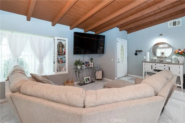 a living room with furniture a flat screen tv and a large window