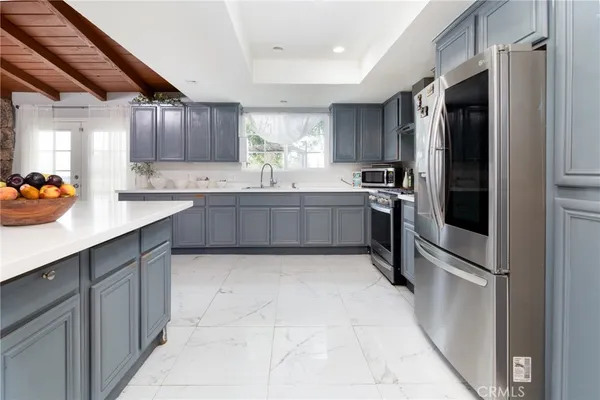 a kitchen with stainless steel appliances granite countertop a refrigerator and a sink