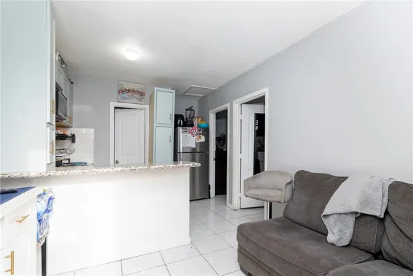 a living room with furniture and a refrigerator