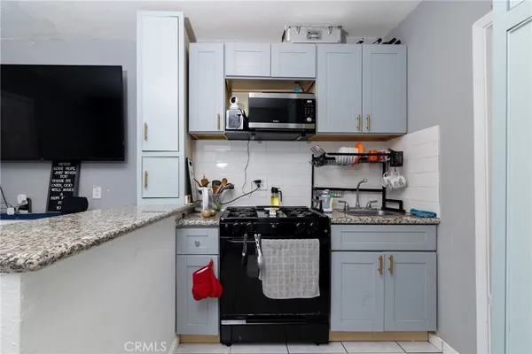 a kitchen with stainless steel appliances granite countertop a stove and a microwave