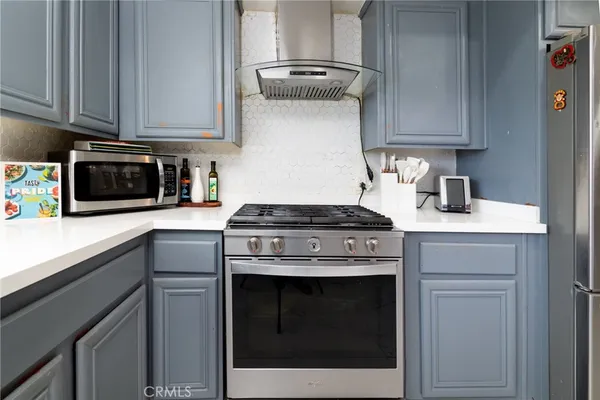 a kitchen with stainless steel appliances granite countertop a stove and a microwave