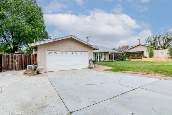 a front view of a house with a yard and trees