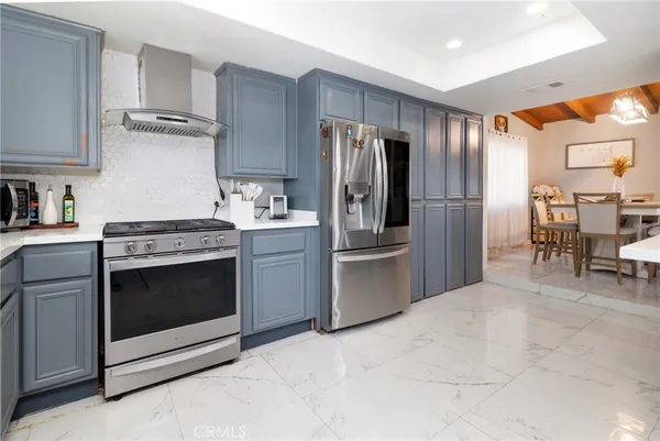 a kitchen with stainless steel appliances granite countertop a stove a refrigerator and a sink