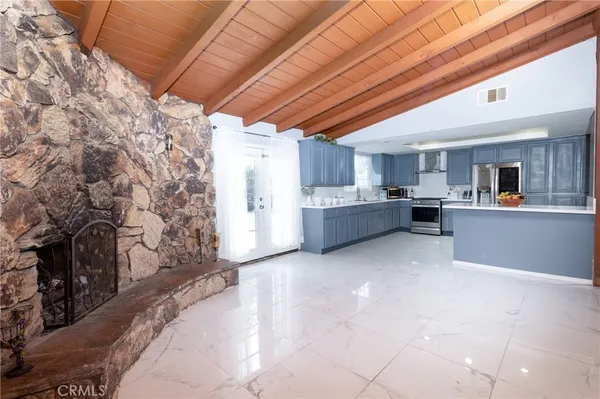 a large white kitchen with cabinets and a fireplace