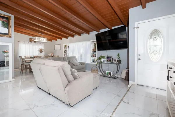 a living room with furniture a flat screen tv and a kitchen island