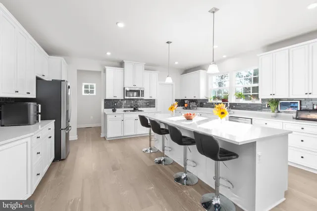 a living room with patio furniture and a kitchen view