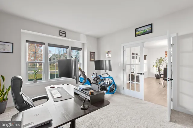 a bedroom with a bed lamp and a large window
