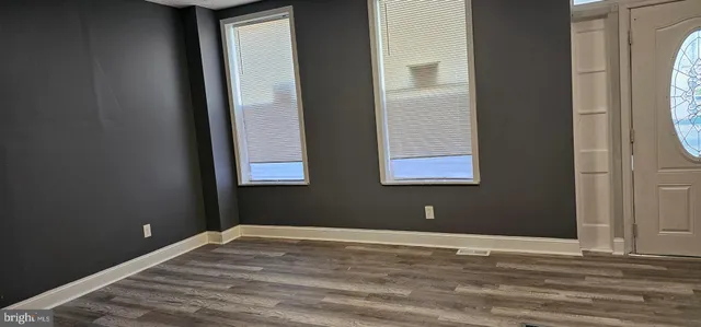 a view of a livingroom with wooden floor and a window