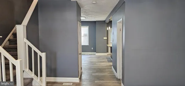 a view of a hallway with wooden floor and staircase