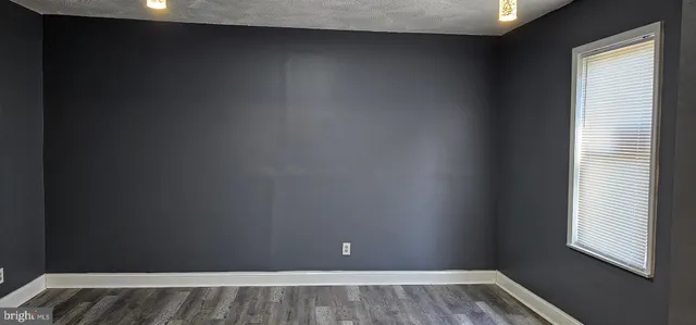 a view of a room with wooden floor and a window