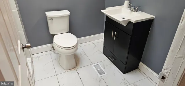 a bathroom with a toilet a sink and mirror