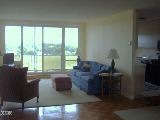 65 Glenbrook Road, Unit 12G Stamford, CT 06902 - Photo 1 of 1 a living room with furniture and a floor to ceiling window