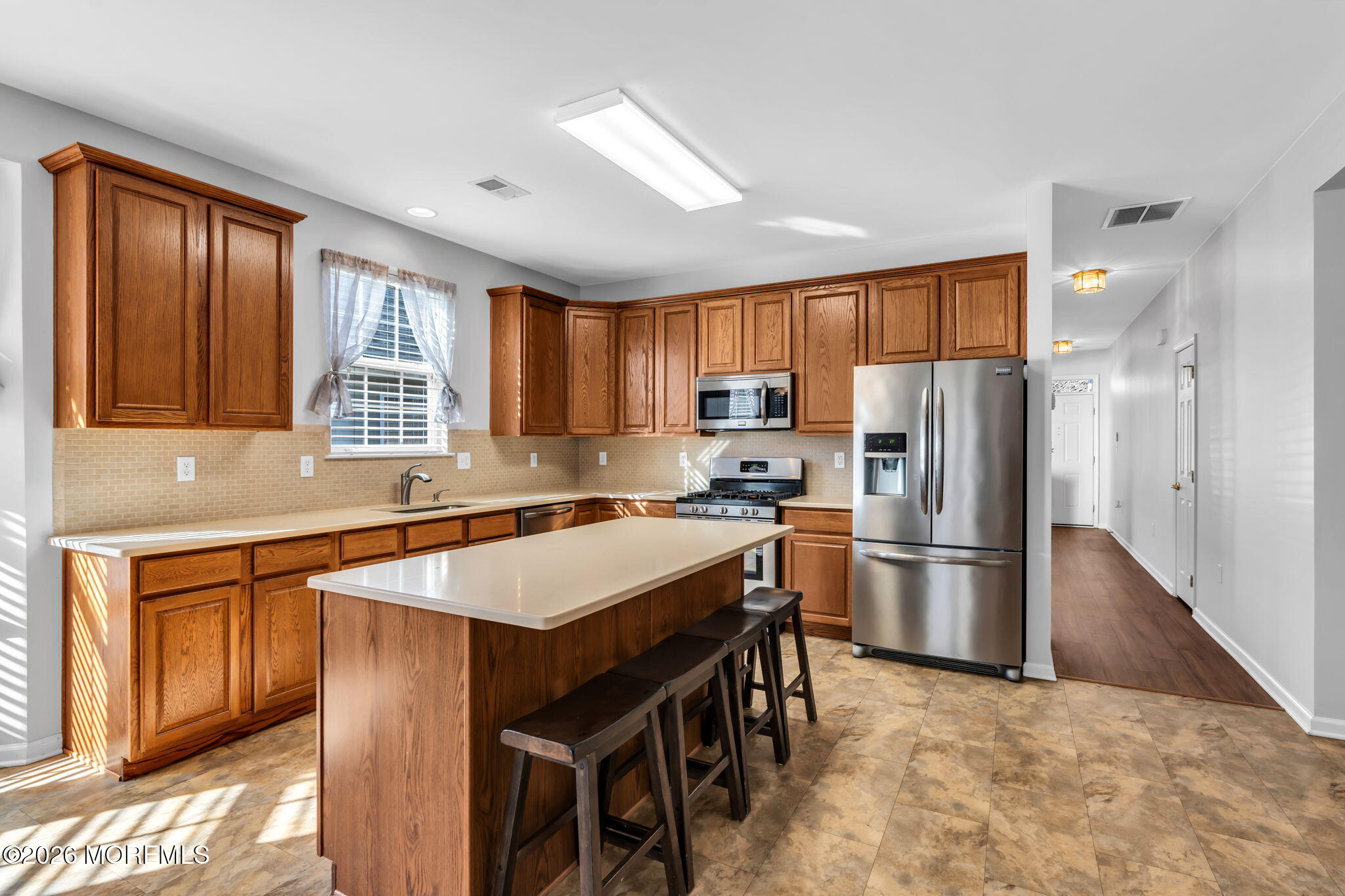 18 Hartack Road Manalapan, NJ 07726 - Photo 14 of 36 a kitchen with stainless steel appliances granite countertop a refrigerator a sink a stove a dining table and chairs