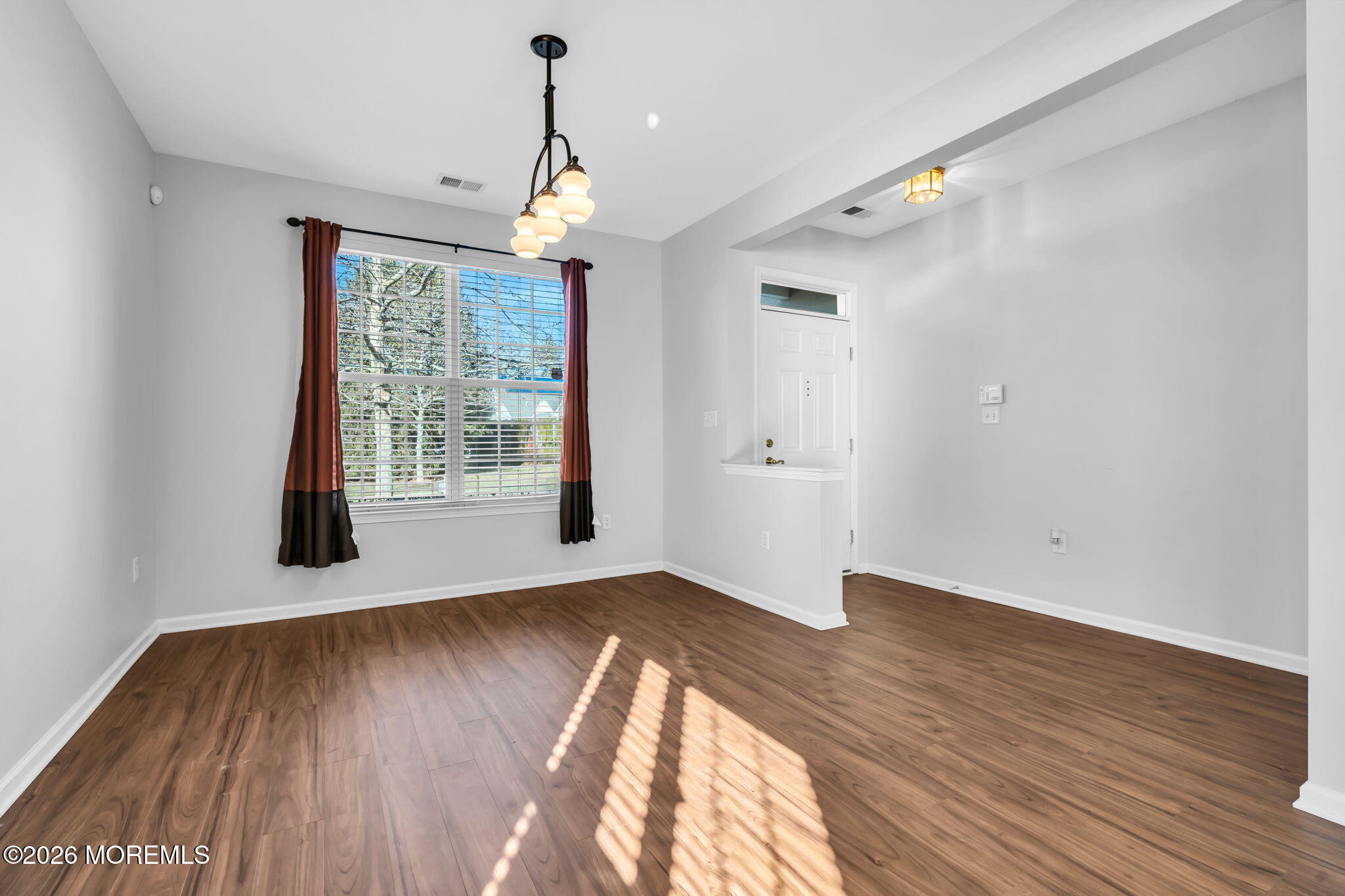 18 Hartack Road Manalapan, NJ 07726 - Photo 6 of 36 an empty room with wooden floor chandelier and windows