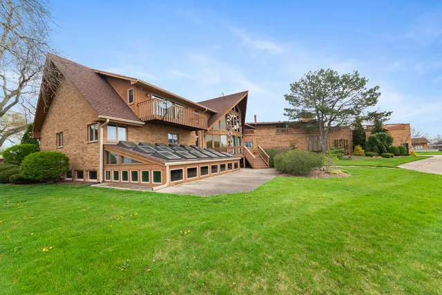 a view of a house with a big yard and large trees