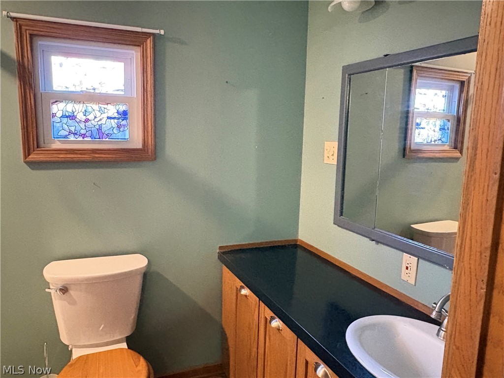 8701 Mayfield Road, Unit 148 Chesterland, OH 44026 - Photo 10 of 22 Master bathroom featuring a a granite countertop, stained glass window, wood-finish window trim, a wall-mounted medicine cabinet, an integrated sink, and wood-finish cabinetry with silver-tone hardware
