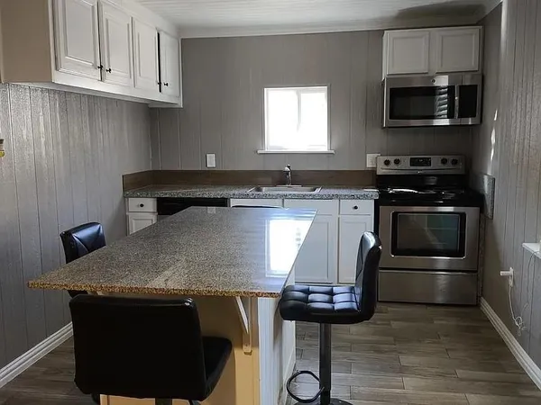 a kitchen with a sink a stove and a microwave