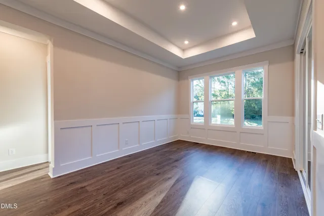 a view of an empty room with wooden floor fireplace and a window