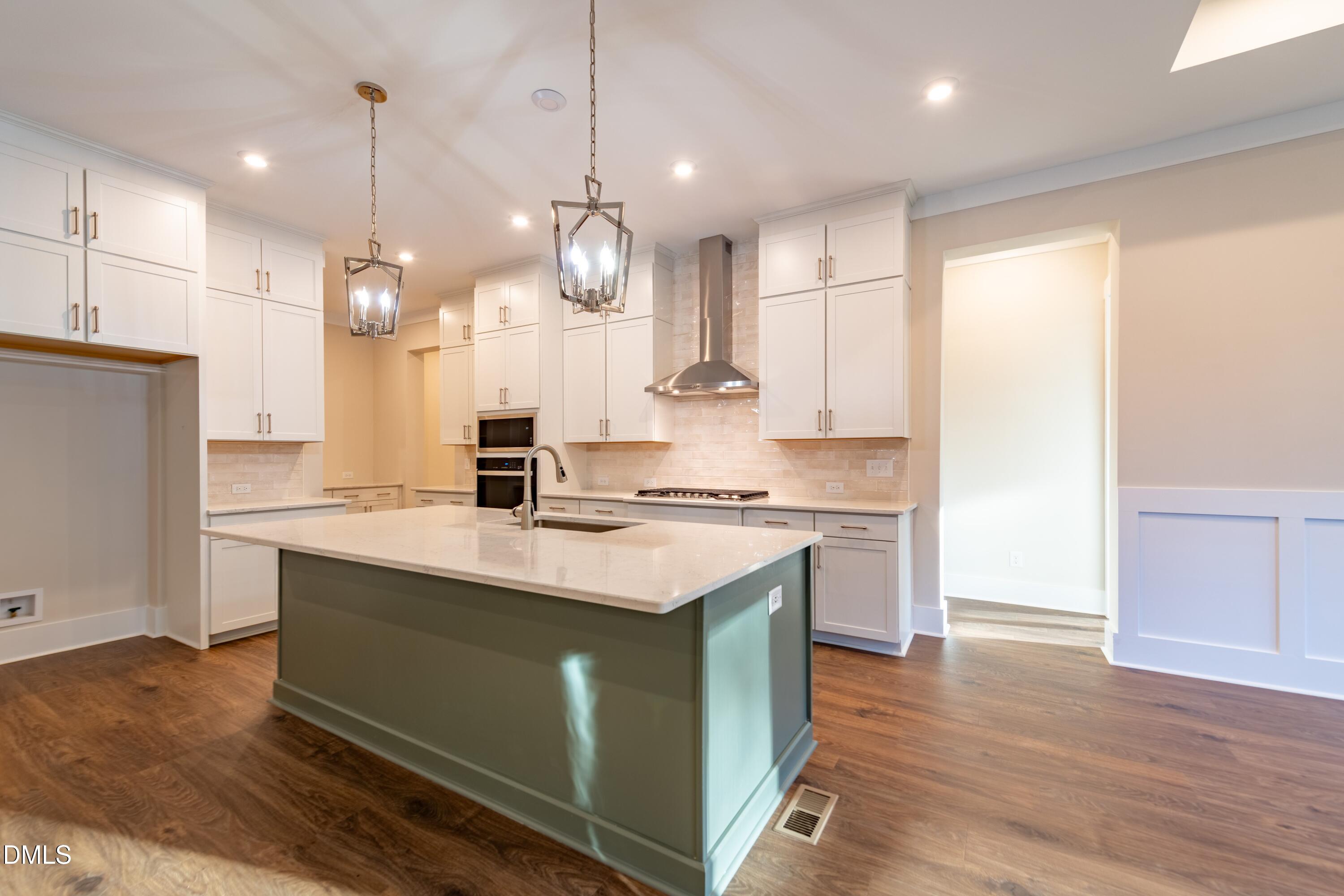 1 Wolf Tree Way Efland, NC 27243 - Photo 3 of 32 a kitchen with kitchen island a sink stainless steel appliances and wooden floor