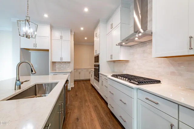 a kitchen with kitchen island a sink stainless steel appliances and wooden floor