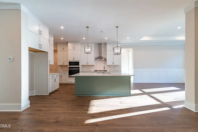 a kitchen with kitchen island stainless steel appliances a stove a sink a refrigerator and cabinets