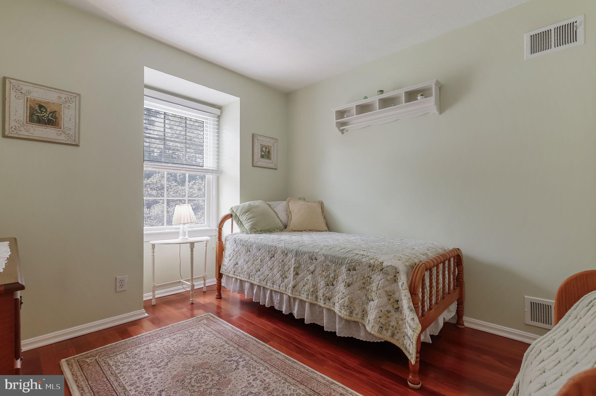 12705 Ruxton Road Silver Spring, MD 20904 - Photo 31 of 44 a bedroom with a bed and wooden floor