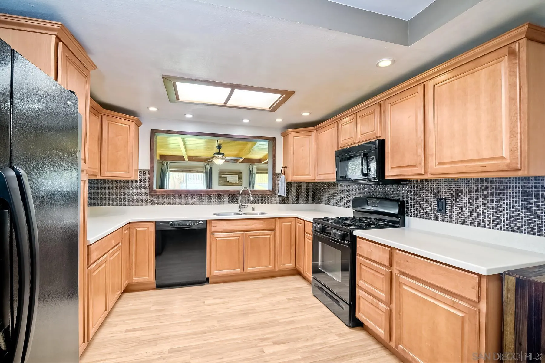2162 Rising Glen Way San Diego, CA 92139 - Photo 4 of 48 a kitchen with stainless steel appliances granite countertop a stove a sink dishwasher a refrigerator and a microwave oven with wooden floor