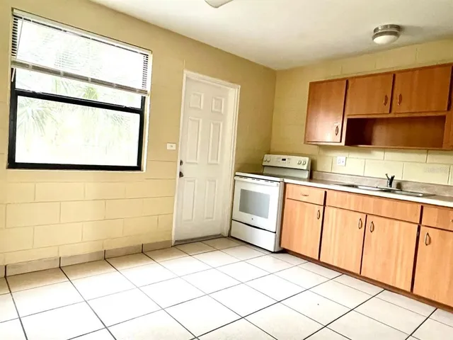 a kitchen with a refrigerator sink stove and cabinets