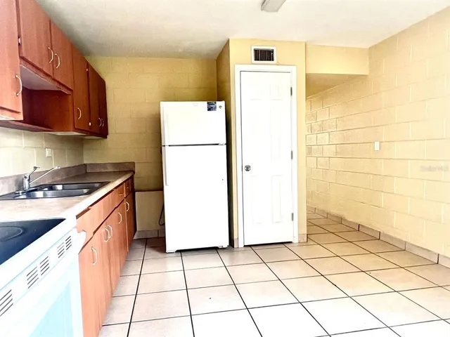 a view of an empty room and kitchen