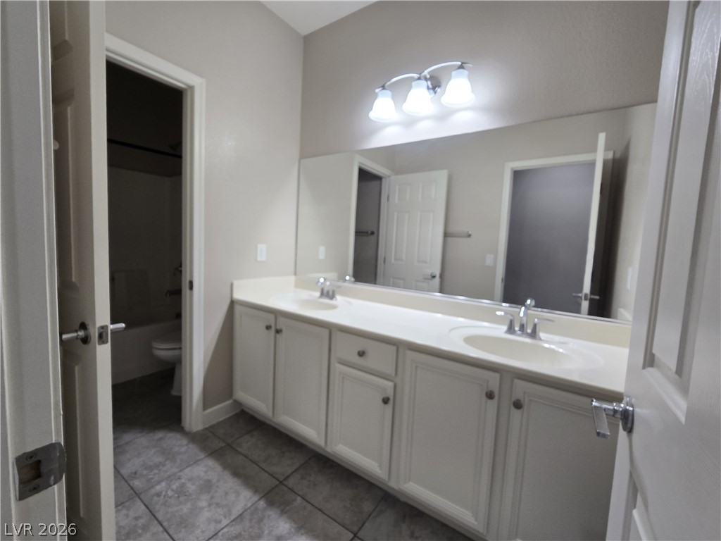 8059 Encanterra Road Las Vegas, NV 89113 - Photo 22 of 30 A well-appointed bath features a double vanity and sleek tile flooring, offering ample personal space.