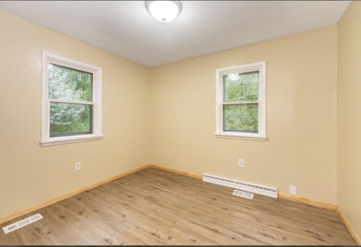 126 Jay Cooke Road Esko, MN 55733 - Photo 11 of 19 Unfurnished room with wood finished floors and a baseboard radiator