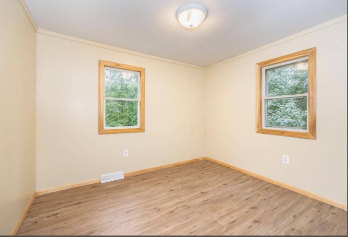 126 Jay Cooke Road Esko, MN 55733 - Photo 8 of 19 Empty room with wood finished floors and ornamental molding
