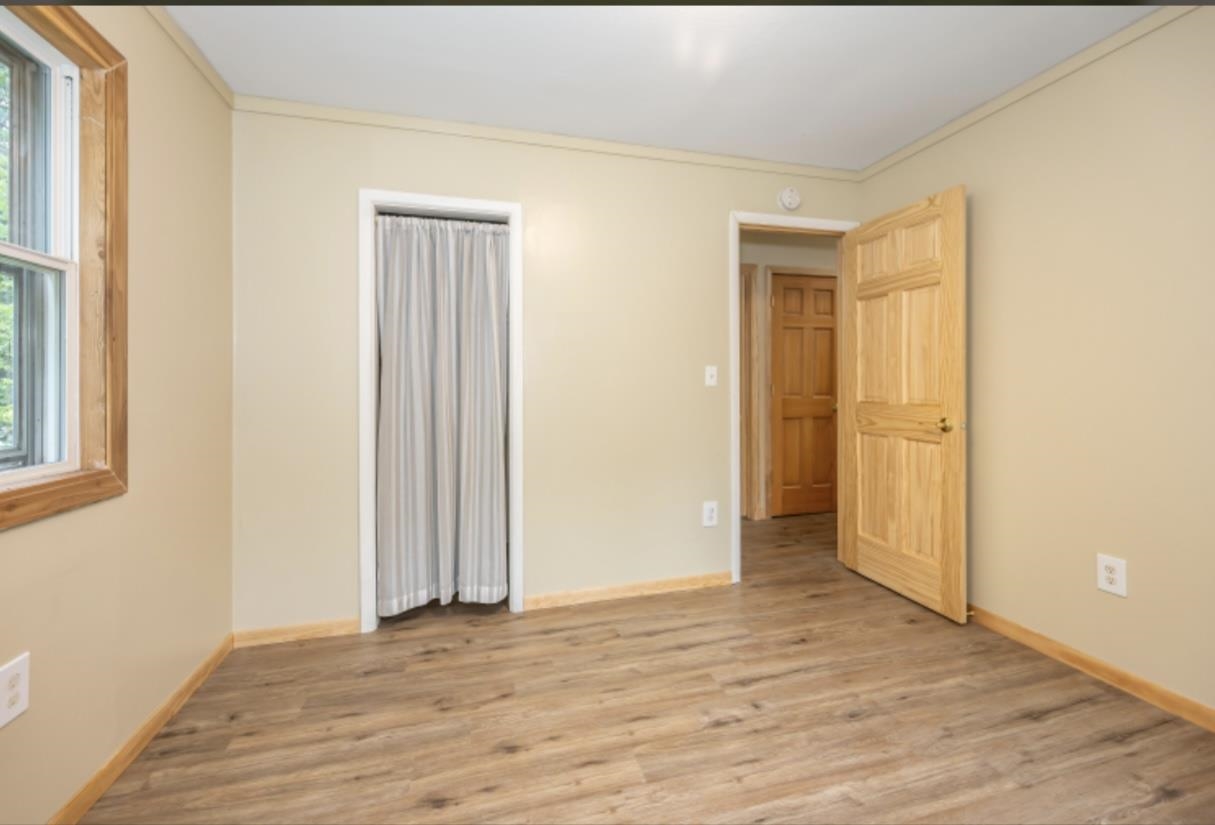 126 Jay Cooke Road Esko, MN 55733 - Photo 10 of 19 Unfurnished bedroom with light wood-style flooring, ornamental molding, and multiple windows