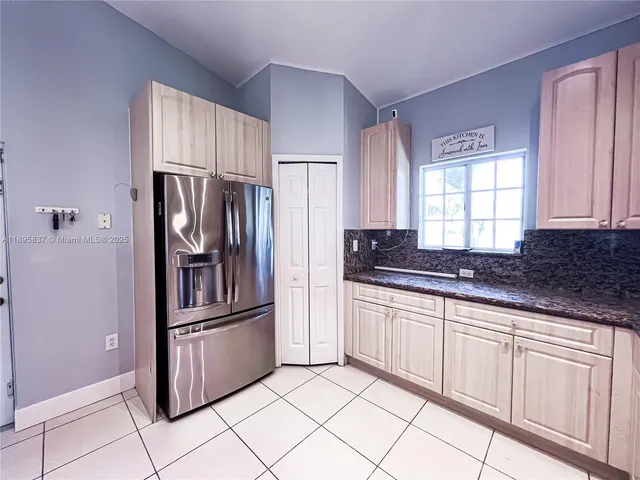 a kitchen with granite countertop a refrigerator and a sink
