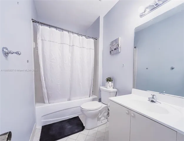 a bathroom with a sink a toilet and shower curtain
